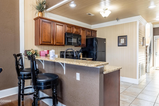 415 Big Bear Way, Pigeon Forge, TN 37863 - kitchen featuring black appliances, crown molding, a kitchen bar, light stone counters, and a peninsula
