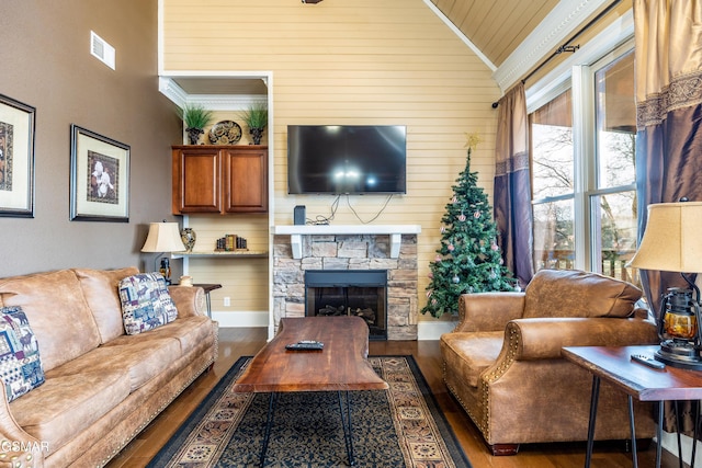 415 Big Bear Way, Pigeon Forge, TN 37863 - living area featuring wood finished floors, wood walls, a stone fireplace, and high vaulted ceiling