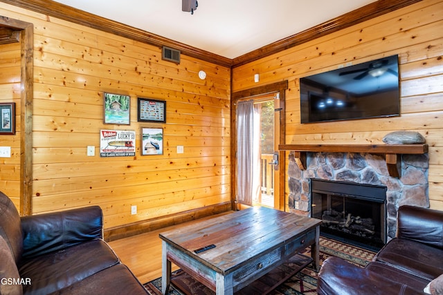415 Big Bear Way, Pigeon Forge, TN 37863 - living room with a ceiling fan, wooden walls, wood finished floors, a stone fireplace, and crown molding