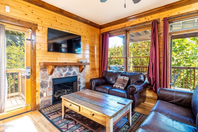 415 Big Bear Way, Pigeon Forge, TN 37863 - living area featuring light wood-style flooring, a ceiling fan, wooden walls, a fireplace, and ornamental molding
