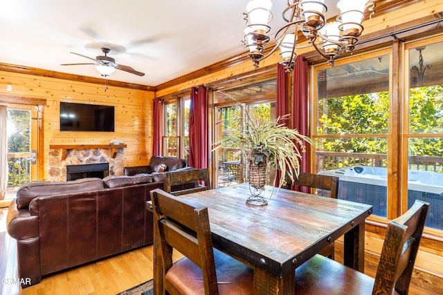 415 Big Bear Way, Pigeon Forge, TN 37863 - dining space featuring wooden walls, light wood-style flooring, ceiling fan, a stone fireplace, and crown molding