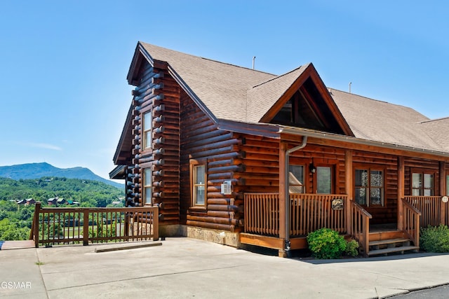 415 Big Bear Way, Pigeon Forge, TN 37863 - view of front facade featuring log exterior, a porch, a mountain view, and roof with shingles