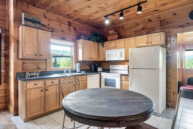 415 Big Bear Way, Pigeon Forge, TN 37863 - kitchen featuring white appliances, rail lighting, light tile patterned floors, plenty of natural light, and wood walls