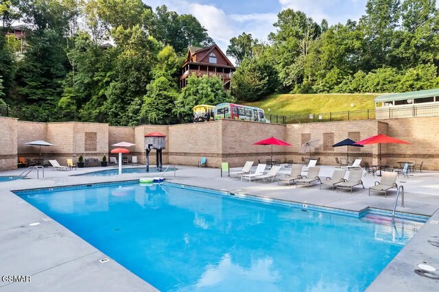 668 Stockton Dr, Sevierville, TN 37876 - community pool with view of wooded area and a patio