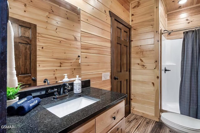 668 Stockton Dr, Sevierville, TN 37876 - full bathroom featuring vanity, wood walls, wood finished floors, and curtained shower