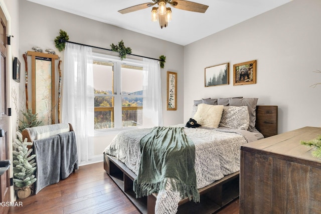 bedroom with ceiling fan, dark hardwood / wood-style flooring, and multiple windows