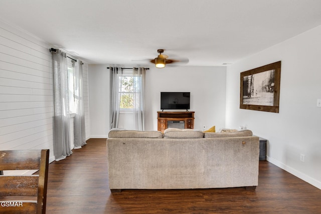 unfurnished living room featuring ceiling fan and dark wood-type flooring