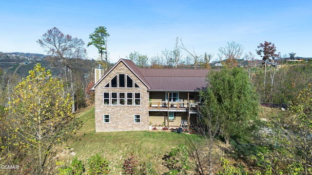 rear view of house with a lawn and a wooden deck