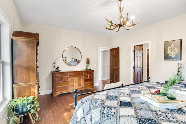 bedroom with an inviting chandelier and dark wood-type flooring