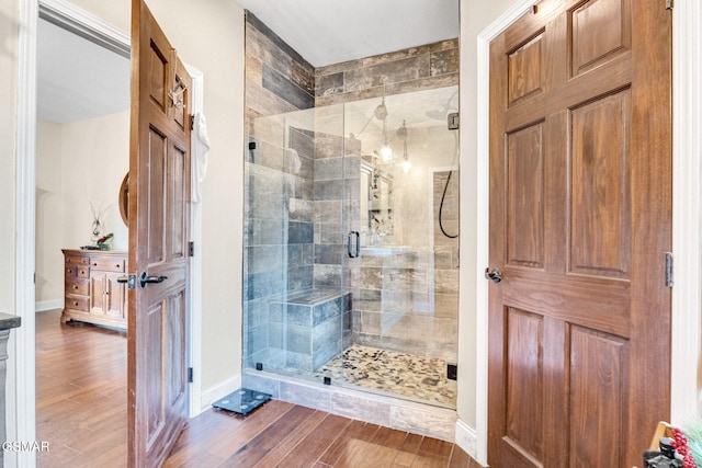 bathroom with wood-type flooring and a shower with door