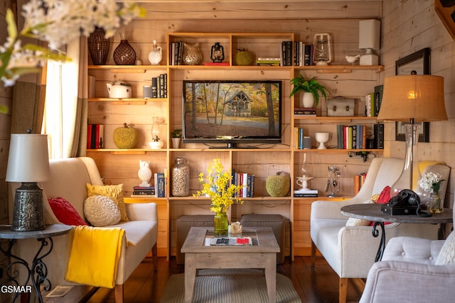 sitting room with wood walls and wood finished floors