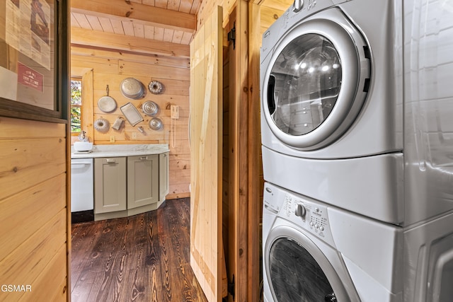 laundry room featuring laundry area, wooden walls, wooden ceiling, dark wood-style floors, and stacked washing maching and dryer