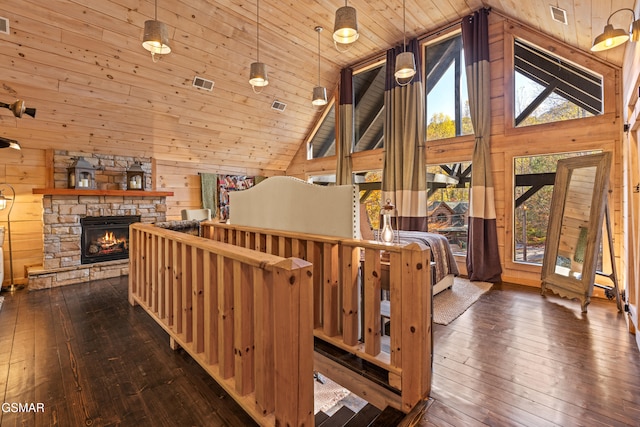 interior space with high vaulted ceiling, a wealth of natural light, dark wood-style flooring, and wooden walls