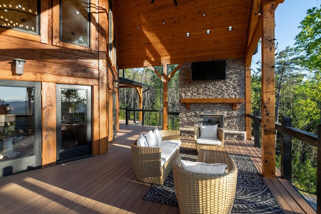 wooden terrace with an outdoor stone fireplace