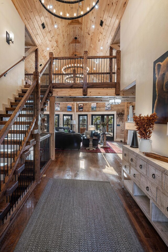 interior space with a high ceiling, dark hardwood / wood-style flooring, and wooden ceiling