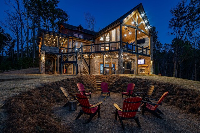 back house at twilight with a balcony and a fire pit