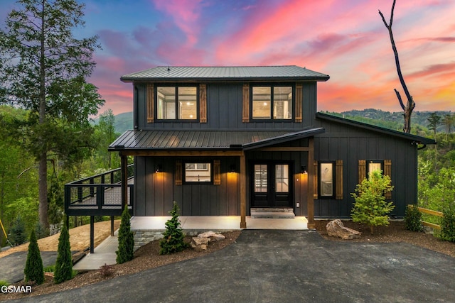 view of front of house featuring board and batten siding, french doors, and metal roof