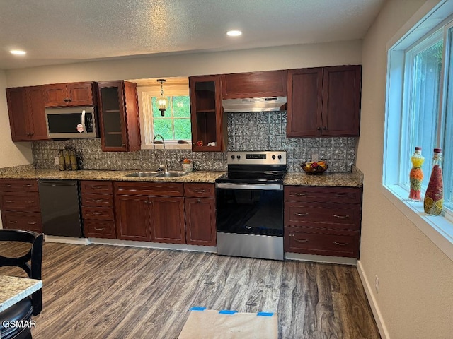 3979 Wilhite Rd, Sevierville, TN 37876 - kitchen featuring appliances with stainless steel finishes, under cabinet range hood, dark wood-style floors, tasteful backsplash, and glass insert cabinets