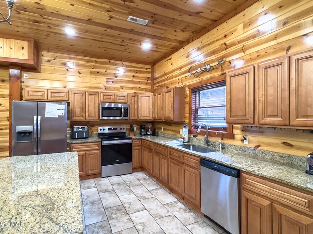 2316 Boulder Way, Sevierville, TN 37862 - kitchen featuring appliances with stainless steel finishes, a sink, wood ceiling, brown cabinets, and light stone countertops