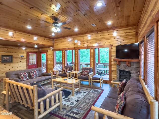 2316 Boulder Way, Sevierville, TN 37862 - living room featuring recessed lighting, ceiling fan, wood walls, wooden ceiling, and a stone fireplace