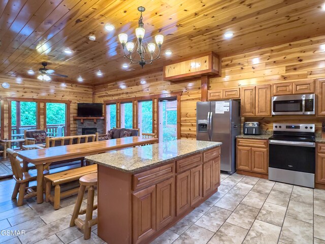 2316 Boulder Way, Sevierville, TN 37862 - kitchen with appliances with stainless steel finishes, wood ceiling, a ceiling fan, a stone fireplace, and a chandelier