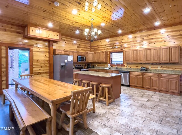 2316 Boulder Way, Sevierville, TN 37862 - kitchen featuring appliances with stainless steel finishes, a sink, a chandelier, brown cabinets, and a kitchen island