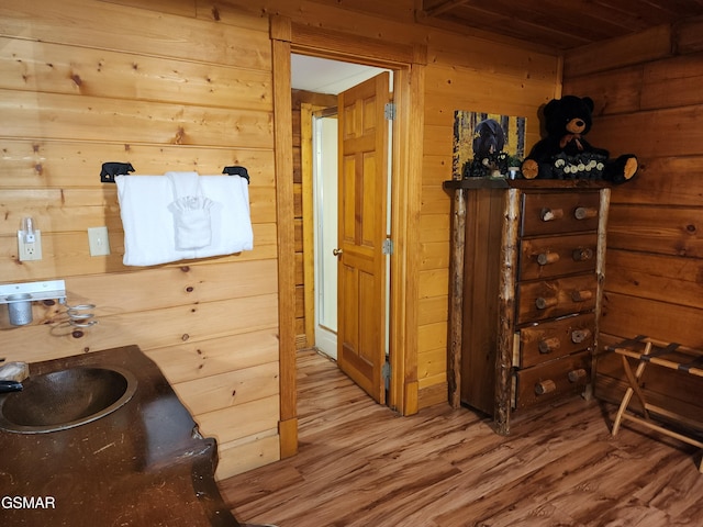 bathroom with hardwood / wood-style floors and wooden walls