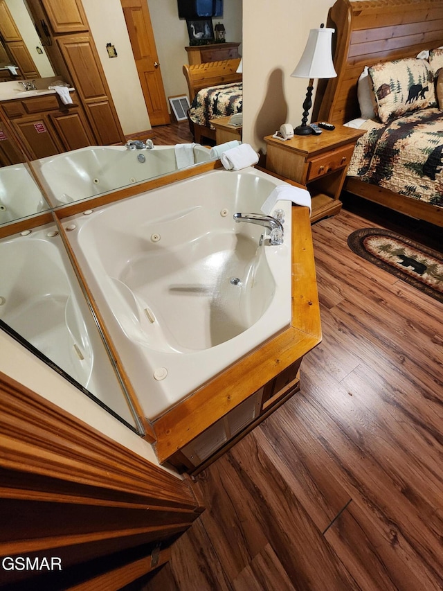 bathroom featuring a washtub, wood-type flooring, and vaulted ceiling