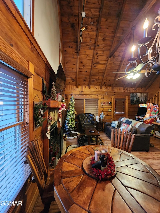 dining space featuring lofted ceiling with beams, wooden walls, wood ceiling, and hardwood / wood-style flooring