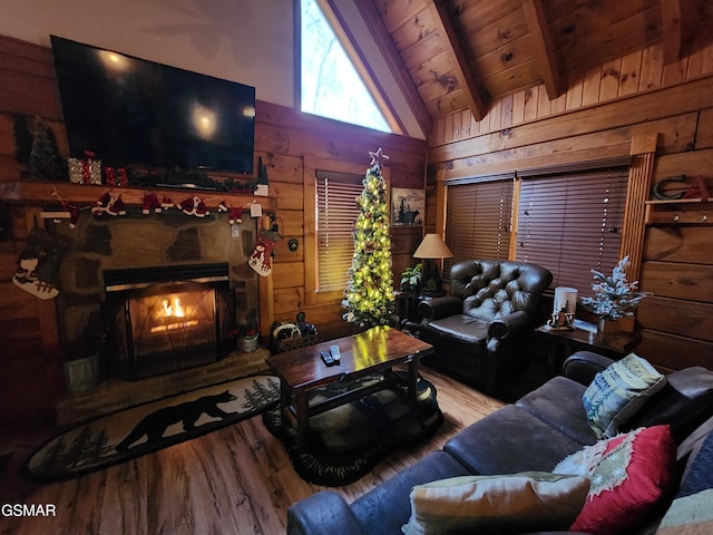 living room with wood ceiling, wood-type flooring, lofted ceiling with beams, a stone fireplace, and wood walls