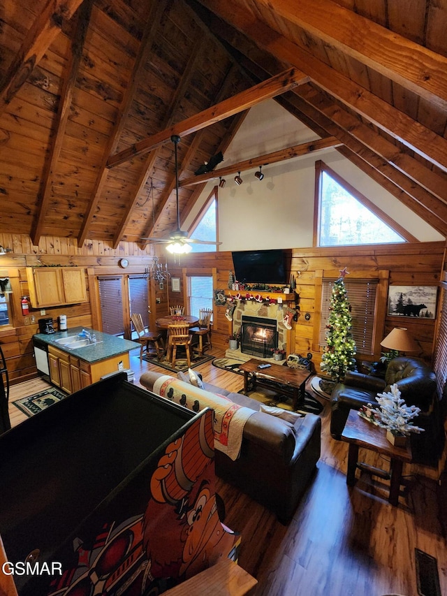 living room with sink, beamed ceiling, dark hardwood / wood-style floors, wood walls, and wood ceiling