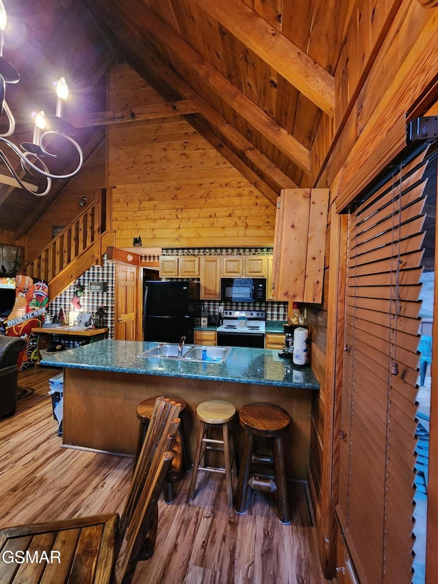 kitchen featuring dark hardwood / wood-style flooring, wood ceiling, black appliances, light brown cabinets, and lofted ceiling with beams