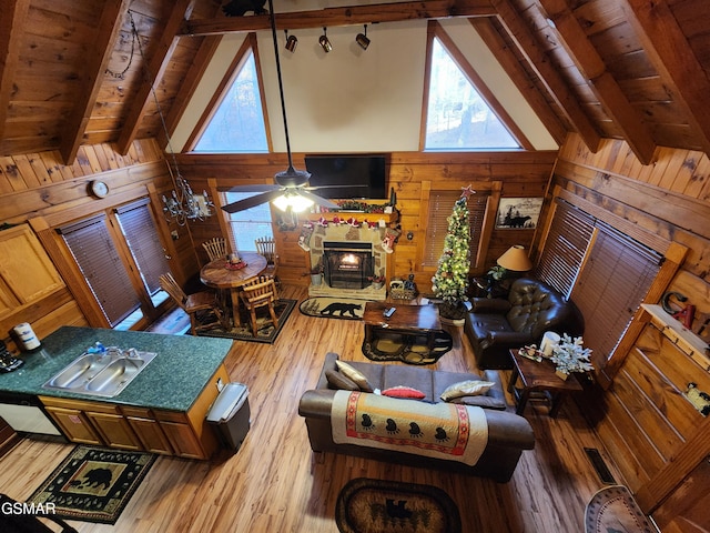 living room featuring wood walls, beam ceiling, wooden ceiling, and sink