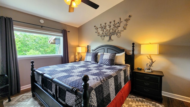bedroom with baseboards, wood finished floors, and lofted ceiling