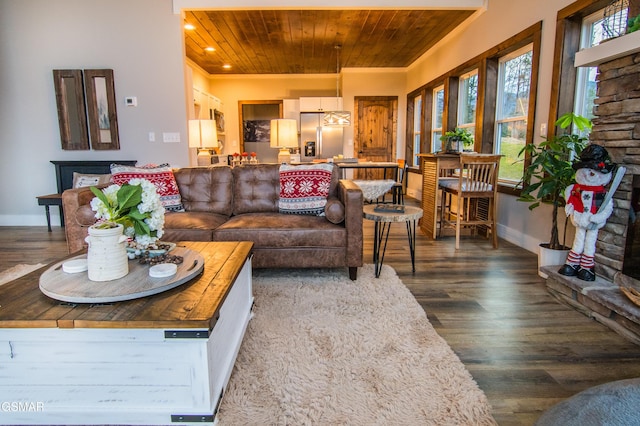 living area with baseboards, wood finished floors, recessed lighting, and wood ceiling