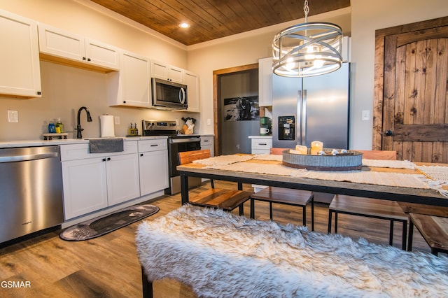 kitchen featuring light countertops, wooden ceiling, light wood finished floors, white cabinets, and appliances with stainless steel finishes