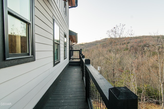 view of property exterior with a balcony and a mountain view