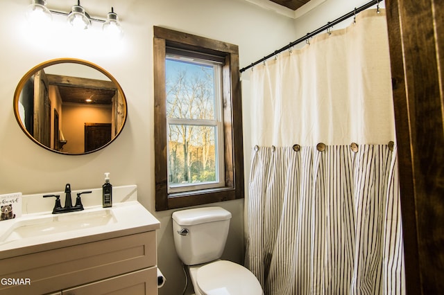bathroom featuring a shower with curtain, toilet, and vanity