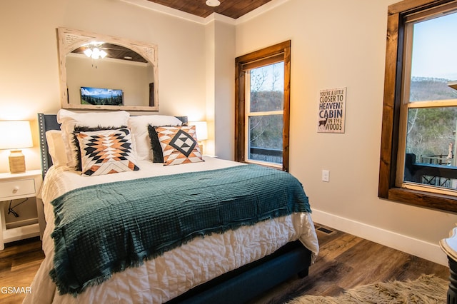 bedroom featuring baseboards, visible vents, and wood finished floors