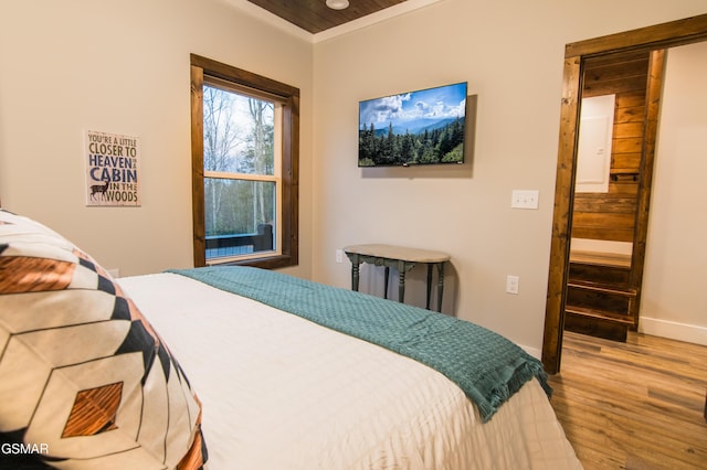 bedroom featuring baseboards, wood finished floors, and radiator heating unit