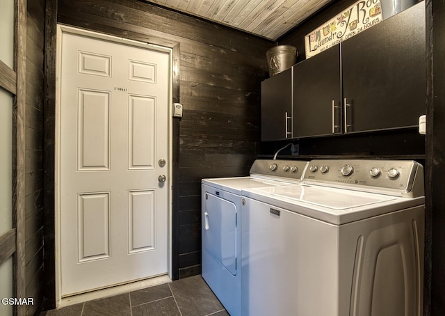 laundry area featuring wood walls, cabinets, dark tile patterned floors, wood ceiling, and washing machine and dryer