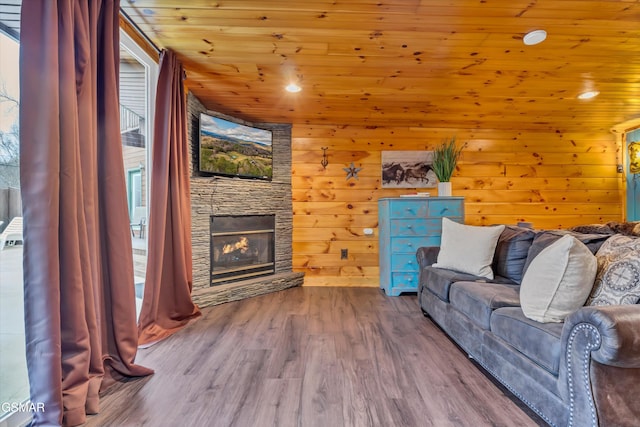 living room with hardwood / wood-style flooring, wooden walls, wood ceiling, and a fireplace