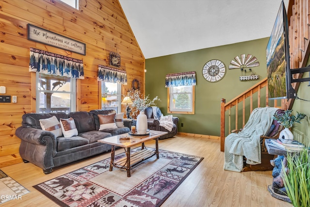 living room featuring hardwood / wood-style flooring, high vaulted ceiling, and wood walls