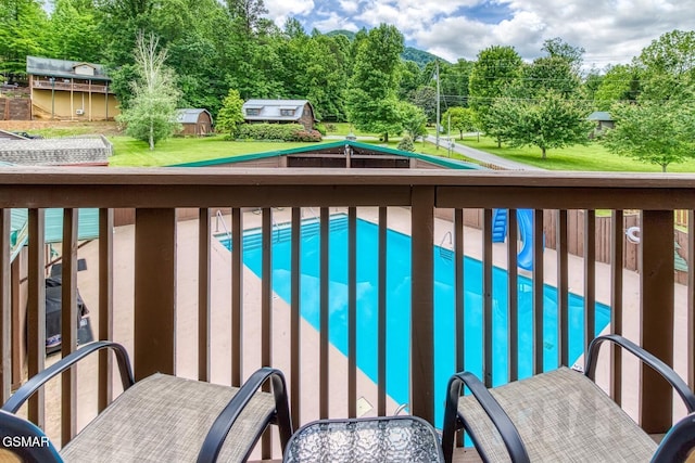 view of pool with a yard and a shed