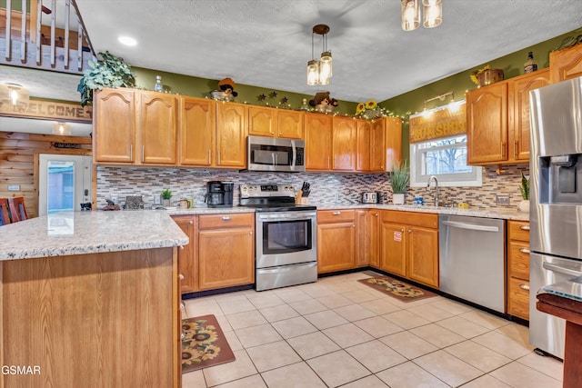 kitchen with light stone countertops, decorative light fixtures, stainless steel appliances, and decorative backsplash