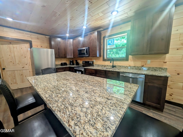 1130 Laddie Buck Ln, Gatlinburg, TN 37738 - kitchen with appliances with stainless steel finishes, a breakfast bar area, light stone countertops, dark wood-type flooring, and wood ceiling