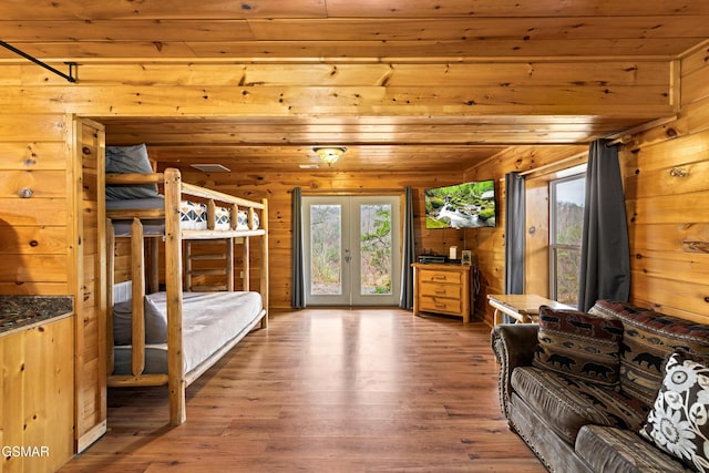 bedroom featuring wood ceiling, access to exterior, wood finished floors, french doors, and wooden walls