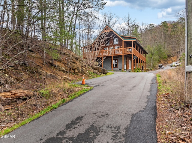 view of front of property featuring a wooden deck and aphalt driveway