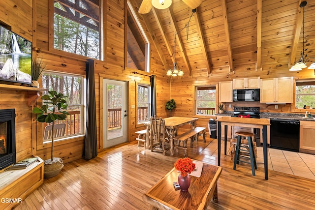 living area featuring wood walls, a wealth of natural light, wooden ceiling, and beamed ceiling