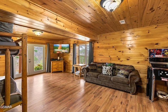 living area featuring wood walls, visible vents, wood ceiling, and wood finished floors